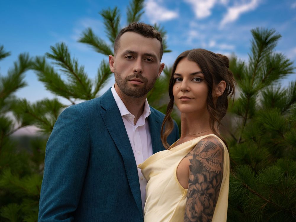 Couple framed by evergreens