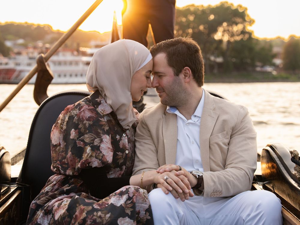 Couple in a gondola on the river at sunset