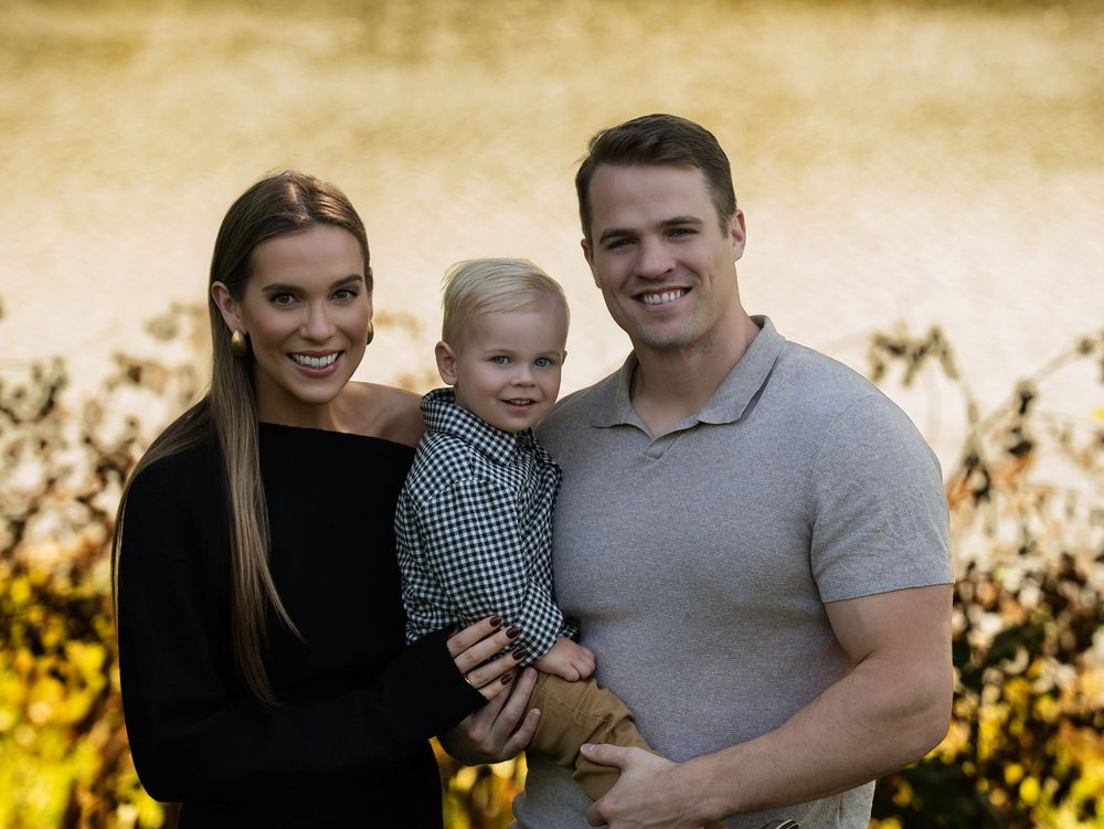 Parents holding their toddler in warm autumn light
