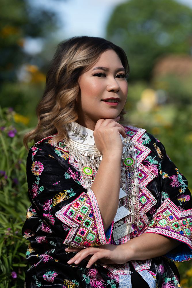 Portrait of a woman in traditional Hmong dress in a garden