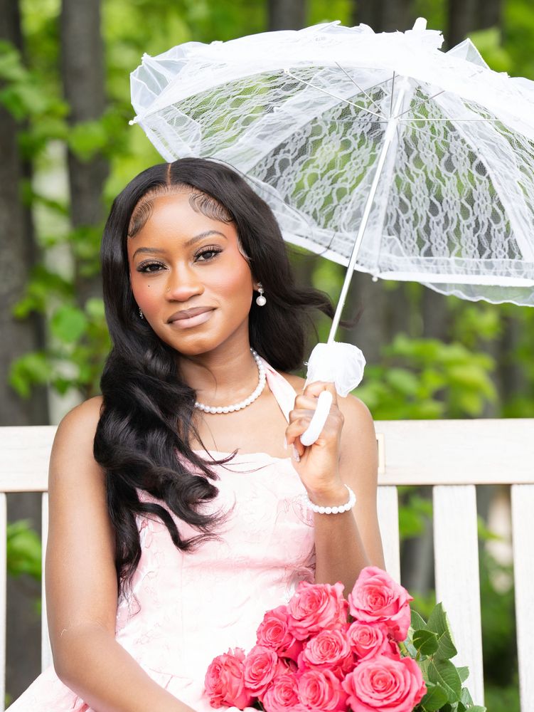 Portrait of a young woman on a white bench holding a lace parasol and pink roses