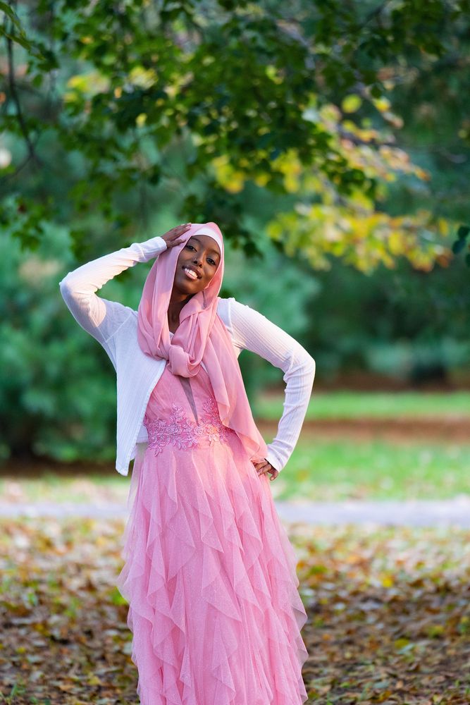 Young woman in a pink dress among fallen leaves