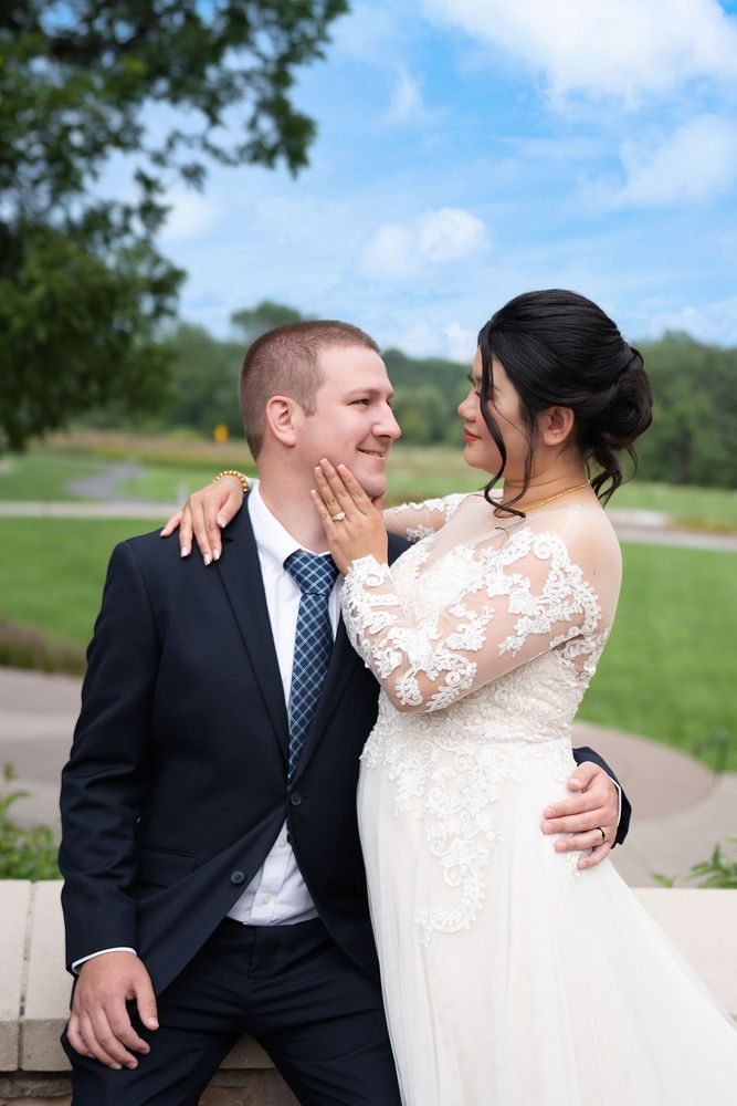Bride touching the groom's face in a garden