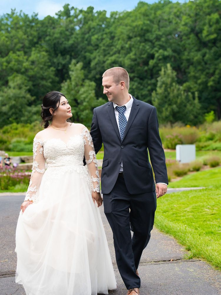 Newlyweds walking hand in hand through a garden